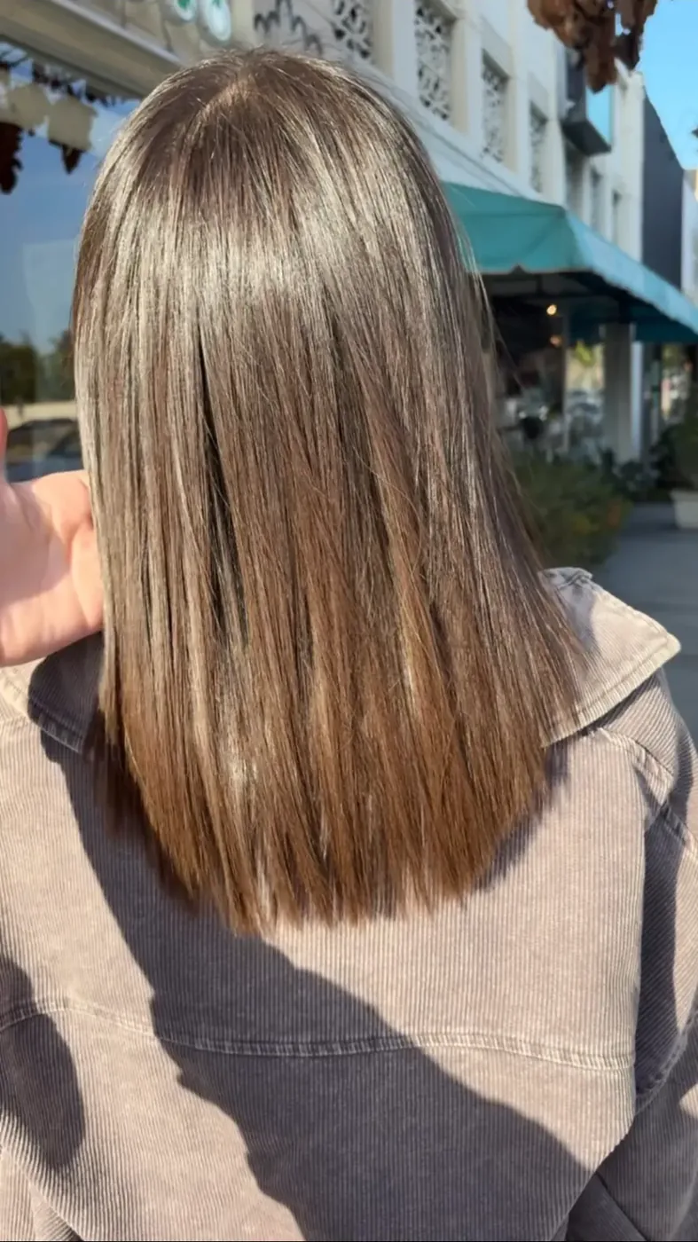 Sleek bronde blunt cut with a glassy straight finish in daylight