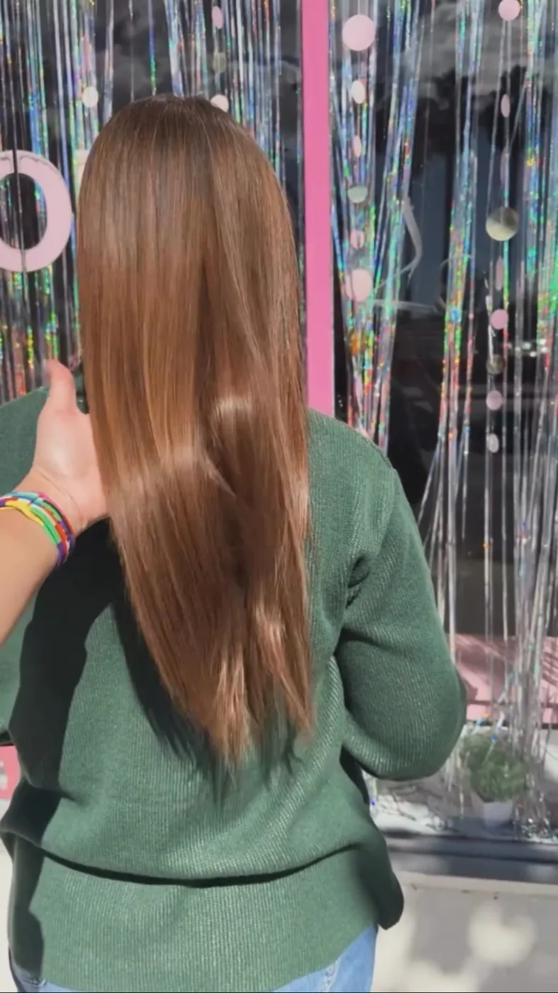 Long chestnut hair with a smooth shiny finish outside the salon